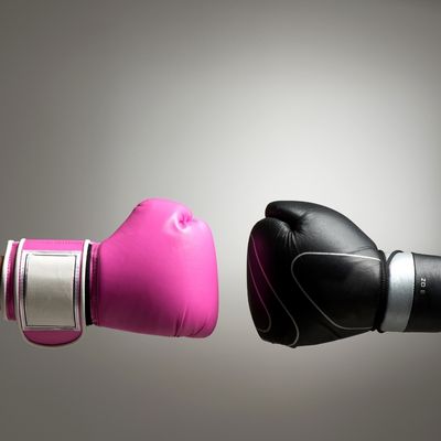 Pink and black boxing gloves facing one another