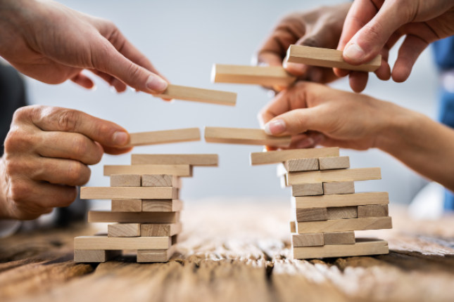 people building bridge from jenga blocks