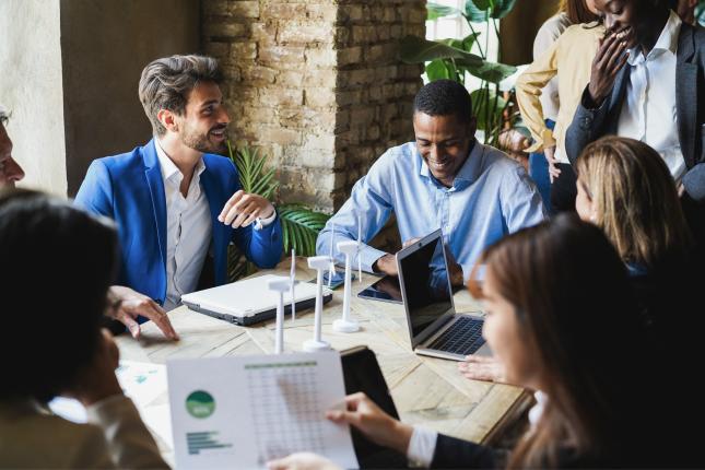 Team sat around table in office looking into green policies 